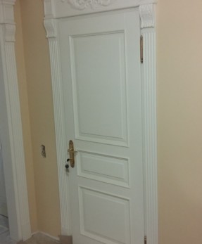 Классическая белая дверь с обкладом и резьбой
