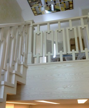 Закрытая  белая деревянная лестница по бетонному основанию